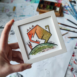 a hand holding a picture of a monster