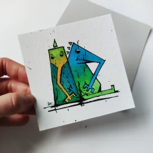 a hand holding a piece of paper with a drawing of two birds