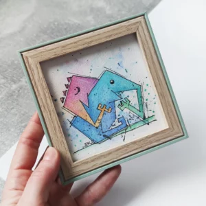 a hand holding a framed picture of a lizard