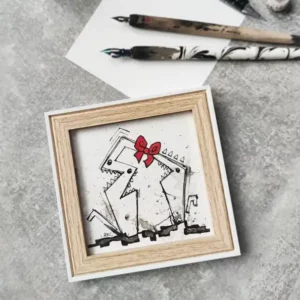 a picture frame with a red bow on it next to brushes and paper